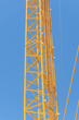 part of yellow construction crane at blue sky background