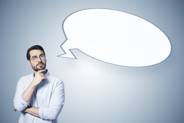 Poster - A man in a thoughtful pose with an empty speech bubble, on a plain background, illustrating the concept of thinking
