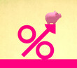© Westend61 - Piggy bank on oversized percentage symbol against yellow background