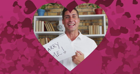 Poster - Image of heart shaped frame with pink hearts over caucasian man proposing on image call