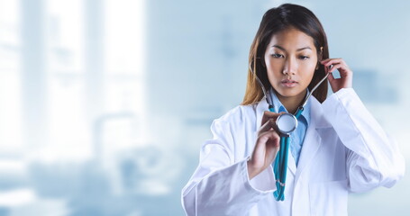 Poster - image of asian female doctor holding stethoscope over blurred background
