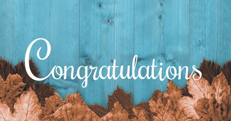 Canvas Print - Brown leaves on blue wood with Congratulations written