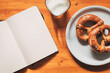 Pretzels and yogurt for breakfast, food and blank notebook on the table