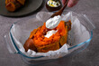 Cooking baked stuffed sweet potato. Adding sour cream sauce into the stuffing