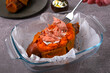 Cooking baked stuffed sweet potato with hot smoked trout and sour cream sauce. Adding the fish on top