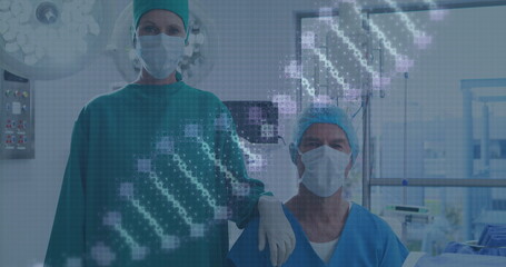 Poster - image of rotating dna over caucasian female and male surgeons in face masks