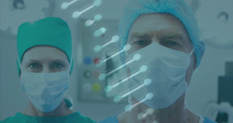 Sticker - Image of rotating dna over caucasian female and male surgeons in face masks