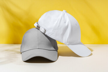 Wall Mural - Baseball hat against yellow background in studio