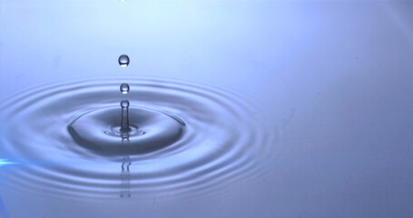 Poster - Image of water drops dropping into blue water with glowing light