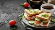Sandwiches with cream cheese, cherry tomatoes, cucumbers and green onions, a cup with black tea.