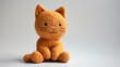 © Andrey - Orange plush cat toy with a cute expression on a plain background.