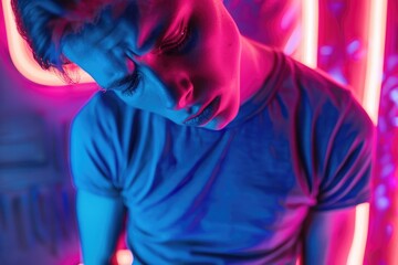 Poster - A man in a blue shirt standing in front of vibrant neon lights. Suitable for urban and nightlife concepts