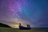 Fototapeta  - Aurora over the Baltic Sea on the beach in Katy Rybackie with fishing boat in Poland.