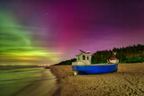 Fototapeta Uliczki - Aurora over the Baltic Sea on the beach in Katy Rybackie with fishing boat in Poland.