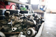 Metal components on workbench in auto repair shop. Mechanics repairing, maintaining car in garage,
