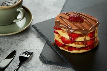 Wall Mural - Tasty pancake with chocolate and fresh strawberries slices