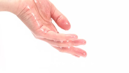 Wall Mural - Big drops of moisturizing lotion with shimmer pouring into hand and flows from the fingers. Beauty concept