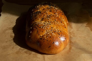 Freshly baked braided brioche sprinkled with nigella and sesame seeds