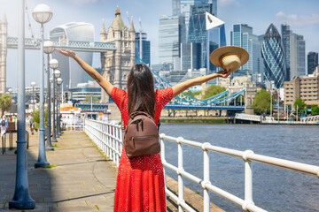 Wall Mural - City traveler concept with a happy tourist woman looking at the skyline of London, England, during a sunny summer day
