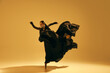 © master1305 - Freedom and inspiration. Young female ballet dancer wearing black flowing costume and dancing against sand color background. Concept of art, classical dance, beauty and fashion, aesthetics