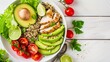 Delicious salad bowl with sliced grilled chicken, avocado, quinoa, cherry tomatoes, and lime garnish