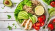 A bowl of salad including grilled chicken, avocado, quinoa, cherry tomatoes, and lettuce leaves on a table