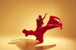 © master1305 - Artistic and deep performance Woman, female dancer in flowing red dress dancing against golden color background. Concept of art, classical dance, beauty and fashion, aesthetics