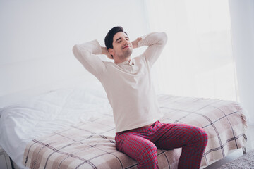 Sticker - Photo of young man sitting on bed waking up in comfortable flat white day light room interior indoors