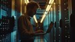 © Антон Сальников - An IT Specialist uses a laptop in a data center. He is situated at a server farm cloud computing facility working on cyber security and network protection. A male maintenance administrator works in a