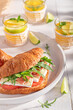 Healthy french croissant with prosciutto, camembert and arugula.