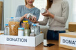 © itchaznong - charity, donation and volunteering concept. Volunteer prepare foodstuff box containing food to donate to people poor, disaster victim at home