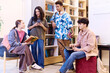 © Seventyfour - Full length portrait of multiethnic group of students chatting in modern school library