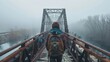 A person with a backpack standing on an old misty railway bridge, facing away from the camera into the foggy distance.