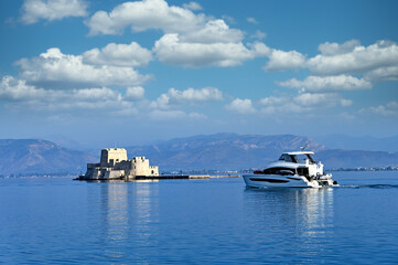 Wall Mural - Luxury yacht sails near Bourtzi Venetian water fortress in Nafplio, Peloponnese, Greece