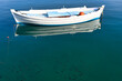 White fishing boat and small fishes in the sea Nafplio Greece