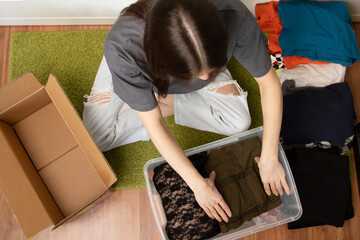 Teenage student packing things to move, carrying heavy boxes down dormitory hallways, campus departure, college relocation.