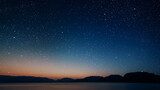 a movement of stars in the night sky with the view of mountains.