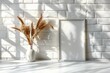Minimalistic Mockup Frame on White Brick Background. Wheat in a Vase Decoration. Empty Frame Mockup in Sun Beams.