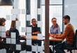 © .shock - In a sleek glass office space, a team of business professionals engage in lively discussions and exchange strategic ideas, showcasing collaboration and innovation at the heart of modern corporate