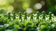 © Suparak - Little green people holding hands in a green park Environmental team for agriculture