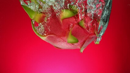 Poster - Super Slow Motion of Falling Dragon Fruit or Pitahaya (Pitaya). Splashing Into Water on Colored Background. Filmed on High Speed Cinema Camera, 1000 fps.