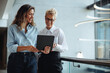 © Jacob Lund - Female executive assistant using a tablet to show her boss a positive business report