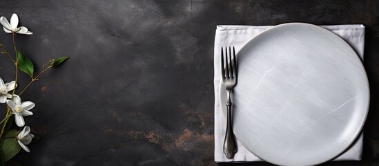 Canvas Print - A top view of a white craft plate cutlery and napkin arranged on a dark stone table The table setting provides a background for a menu with a layout designed to accommodate text and a recipe backgrou