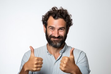 Wall Mural - Portrait of a tender man in his 30s showing a thumb up in front of white background
