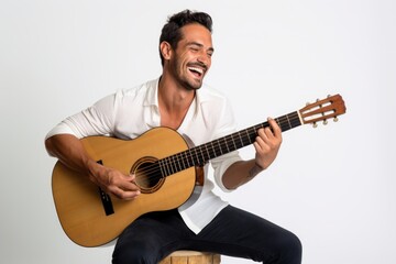 Portrait of a smiling man in his 30s playing the guitar over white background