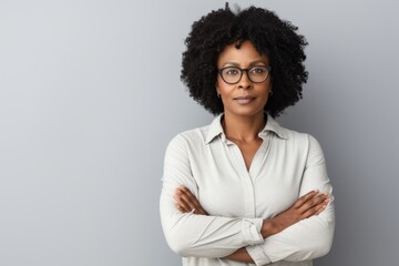 Wall Mural - Portrait of a content afro-american woman in her 40s with arms crossed in white background