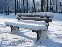 A Serene Snow-covered Park Bench With Minimalist, Raw Style Design Under A Clear Sky.
