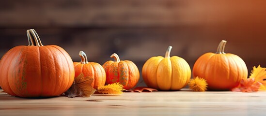Wall Mural - Autumn inspired decorations adorn a wooden table with bright orange pumpkins creating a visually appealing copy space image