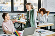© Bliss - Elegant diverse businesswomen working together on project in office, pride flag.