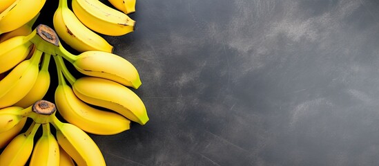 Wall Mural - A top down view of yellow ripe bananas on a concrete gray background with ample empty space for other images or text